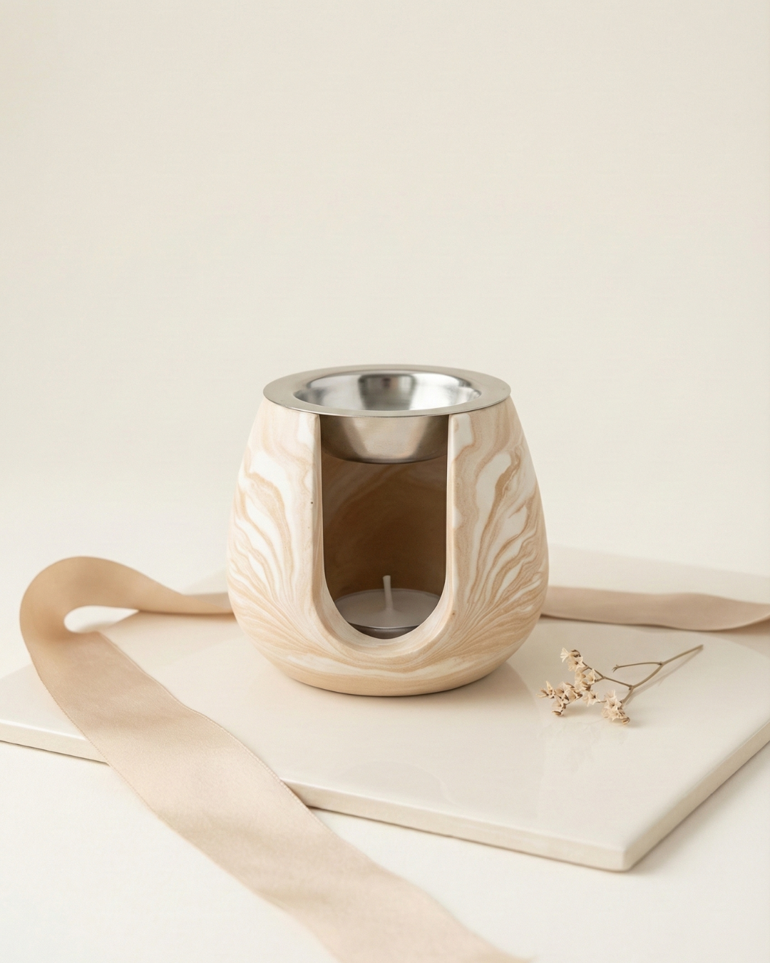 Brûleur pour fondants parfumés vue de face coloris beige marbré avec coupelle en inox.
